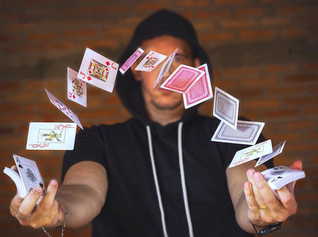 Man doing card trick, euphemism for how Making Small Bets to Build a Successful Side Hustle in a Lot Less Time than You Think