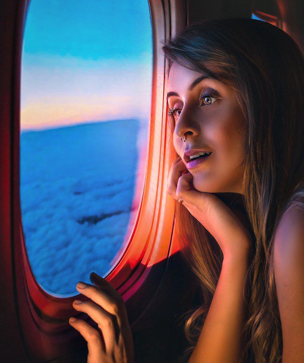 woman looking out plan window as she flies over ocean contemplating habits for 2022
